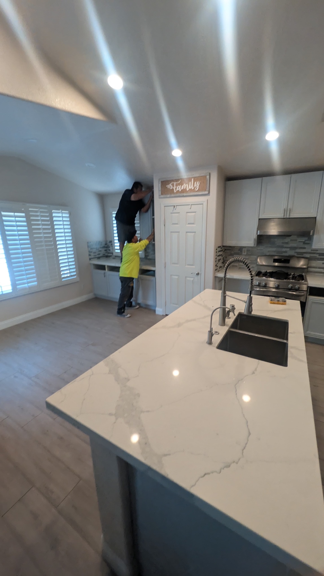 Finished open-concept kitchen with large calacatta quartz island and dual under-mount sinks