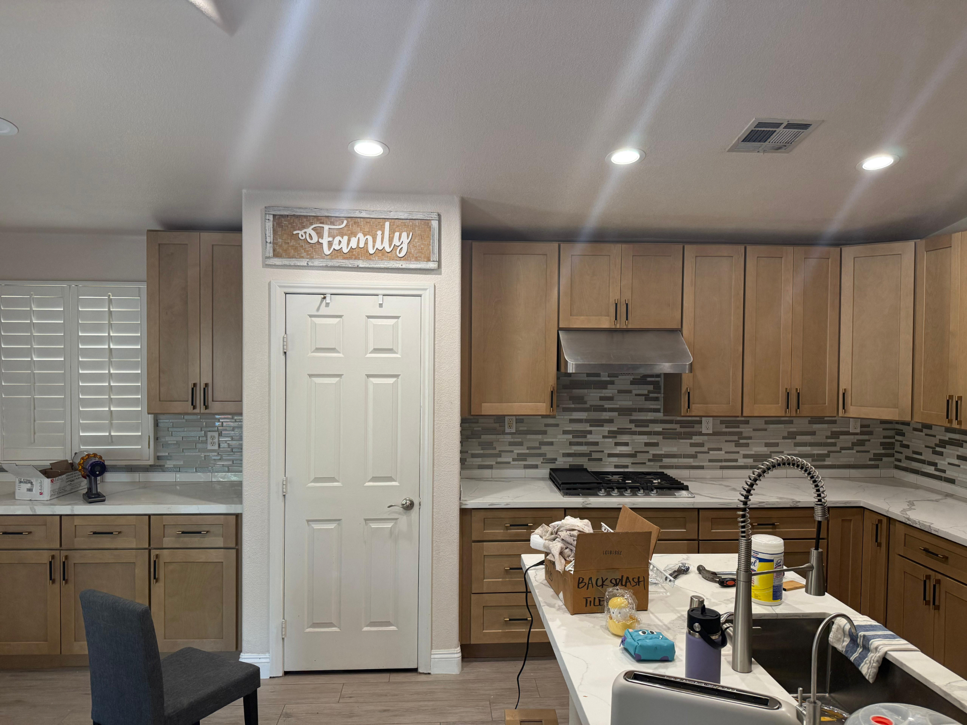 Family-room side of the kitchen with pantry door, range hood and prep island sink
