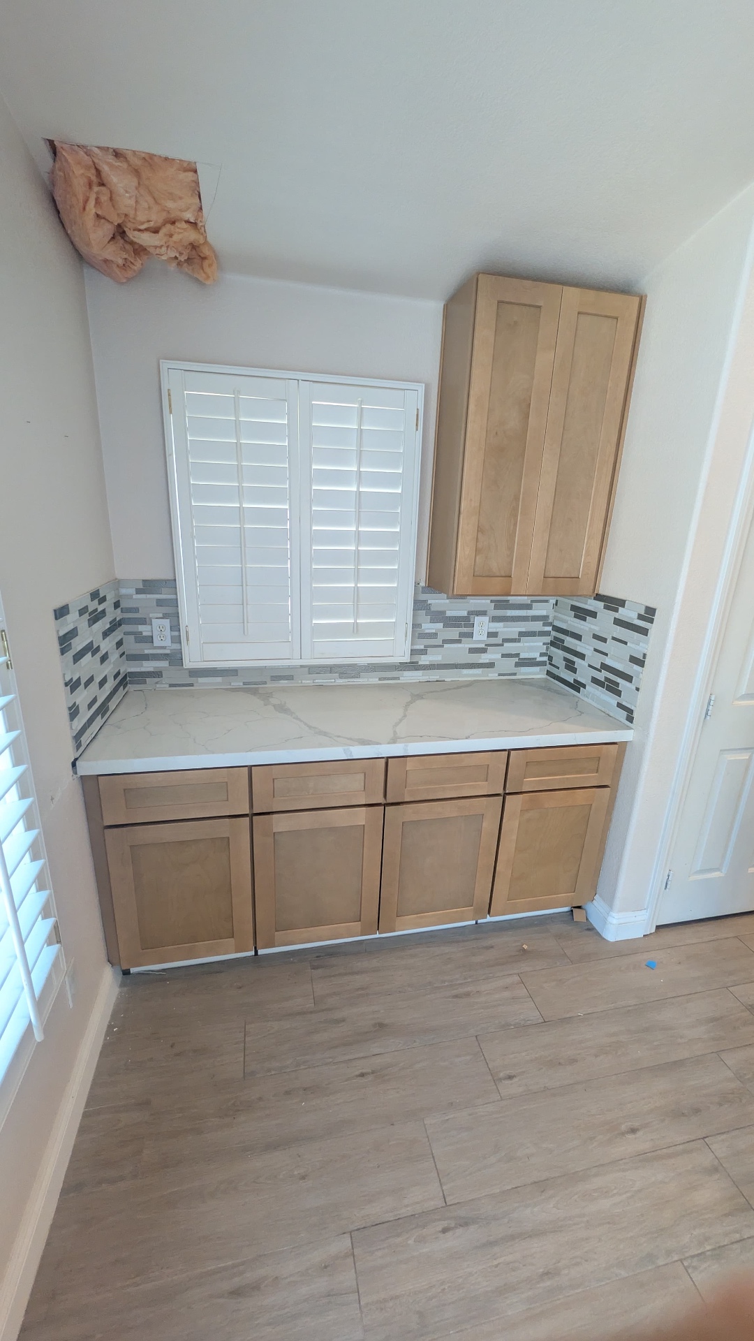 Coffee and beverage bar nook with floor-to-ceiling pantry and plantation shutters