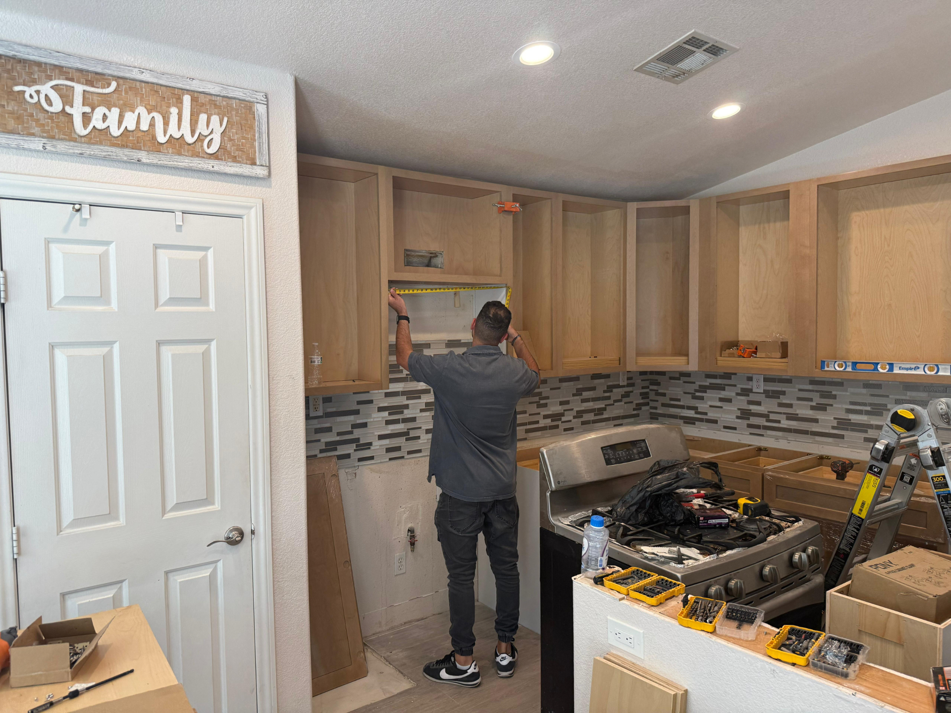 Build4U lead carpenter setting upper cabinets during the Summerlin kitchen remodel