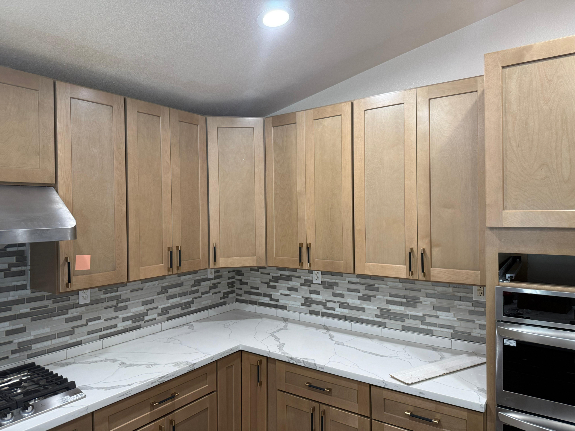 Upper maple shaker cabinets with brushed brass and matte black bar pulls in Summerlin kitchen